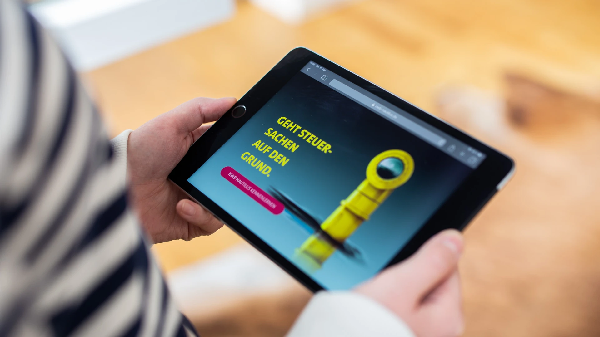 nwb nautilus Praxiswissen im Tiefgang Website auf in Händen gehaltenem Tablet mit Sektion "Geht Steuersachen auf den Grund"